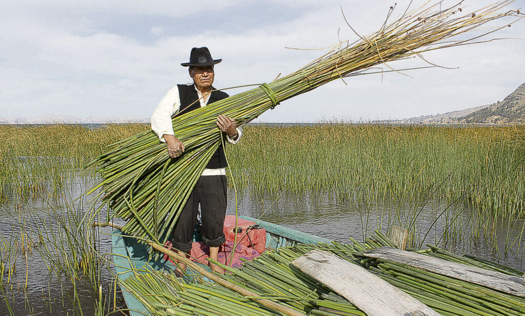 Mujer Uro tejiendo totora en las islas flotantes del lago Titicaca.